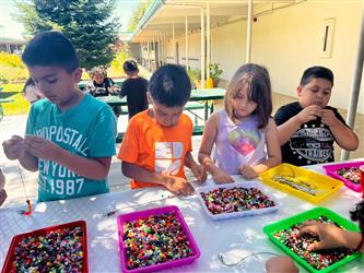 photo of students in summer program making bracelets