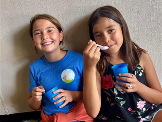 photo of two students in summer program enjoying snow cones