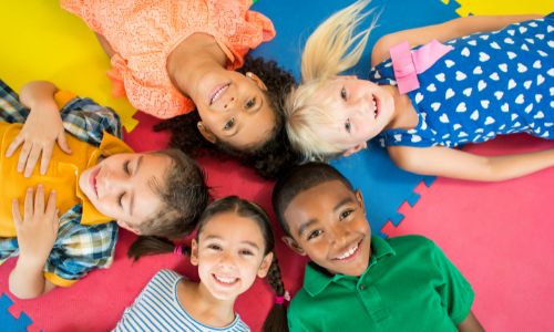 small children laying in a circle
